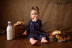 menina na cozinha come bolos doces. foto