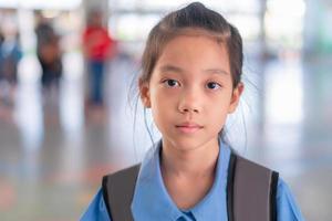 close-up de garota de uniforme escolar, olhando para a câmera sobre fundo desfocado foto