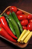 uma foto de close-up de uma tigela de legumes consistindo de pimentão vermelho e verde, tomate cereja e abóbora amarela.