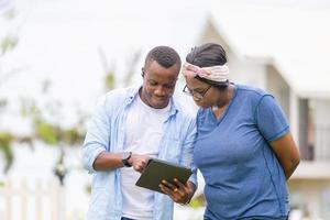 alegre casal afro-americano com tablet digital, conceitos de família de felicidade foto