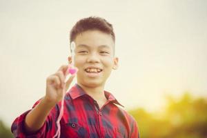 alegre um menino soprando bolhas de sabão no parque, crianças brincando de conceito foto