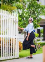 alegre mulher afro-americana de pé e sorrindo para uma nova casa foto