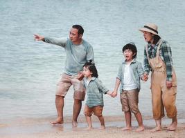 famílias asiáticas se divertindo em férias em uma praia tropical com relacionamentos familiares causaram amor e compreensão para fortalecer a imunidade social. foto