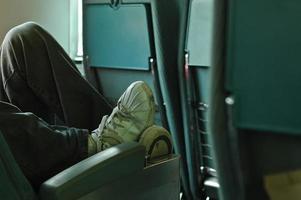passageiro masculino com pés relaxados em um assento de ônibus foto