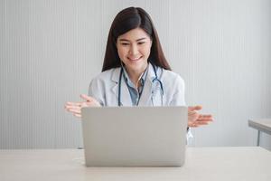 terapeuta asiática médica está visitando on-line com um paciente no aplicativo da internet. ela escuta e dá conselhos e explica como tratar a doença inicial, conceito de tecnologia médica. foto