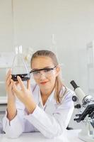 uma bela cientista está operando em um laboratório de ciências com vários equipamentos no laboratório. foto