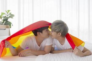 casais masculinos e asiáticos colocam em suas cabeças uma bandeira multicolorida com placas lgbt, expressando homens abertamente gays que aceitam conceitos lgbt. foto