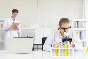 conceito de um pesquisador de saúde, um pesquisador que trabalha em um laboratório de ciências da vida, um jovem pesquisador e um supervisor masculino preparando e analisando lâminas microscópicas em um laboratório de pesquisa foto