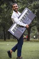 retrato de homem jovem e bonito com música de piano eletrônico foto