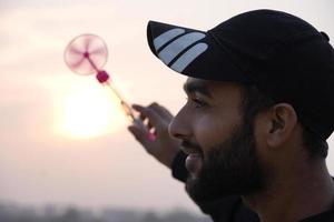 um homem está girando o brinquedo e o sol está no fundo foto