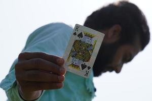 homem com cartas de baralho mostrando a carta do rei - conceito de pôquer foto