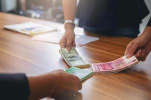 pessoas de negócios segurando dólares usd, yuan rmb, compartilhamento de dinheiro em euros para investimento em câmbio. foco selecionado foto