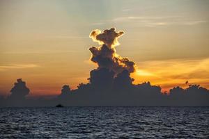 bela nuvem dramática contra a luz colorida do céu pôr do sol foto