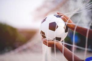 a imagem recortada de jogadores de esportes que pegam a bola e o campo de futebol. conceito de imagem esportiva. foto