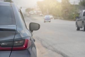 estacionamento cinza ao lado da estrada de terra. com outros carros dirigindo na estrada asfaltada. ambiente na noite do país. foto