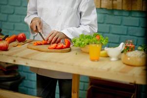 mão do chef, cozinhar salada de legumes, conceito de culinária saudável foto