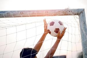 a imagem recortada de jogadores de esportes que pegam a bola e o campo de futebol. conceito de imagem esportiva. foto