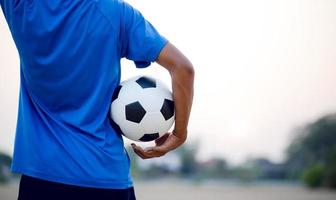 a imagem recortada de jogadores de esportes que pegam a bola e o campo de futebol. conceito de imagem esportiva. foto