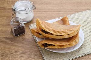 kue lekker. comida de rua holandesa-indonésia, crepes crocantes com recheio de chocolate. foto