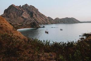 um veleiro flutuando no mar cercado por colinas perto da ilha de padar labuan bajo foto