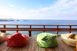 varanda aconchegante com saco de feijão colorido e vista para o mar foto