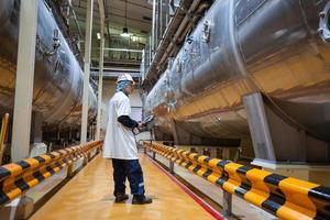 processo de inspeção de trabalho masculino adega de leite em pó com tanques horizontais de aço inoxidável foto