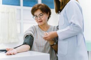 close-up médico verificando a pressão arterial do paciente sênior. assistência médica. foto