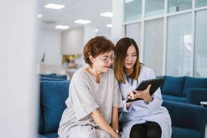 jovem médico consultando paciente sênior na clínica de saúde foto