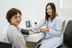 médico verificando a pressão arterial do paciente sênior. assistência médica. foto