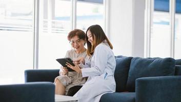 jovem médico consultando paciente sênior na clínica de saúde foto