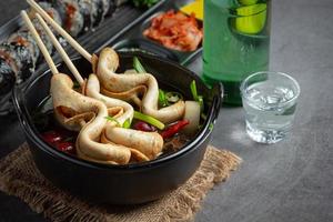 bolo de peixe coreano e sopa de legumes na mesa foto