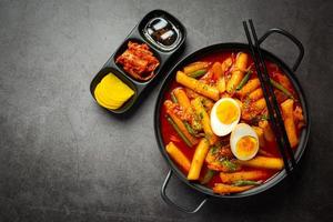 comida tradicional coreana de queijo tokbokki no fundo da placa preta. prato de almoço. foto