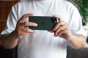 homem usando um telefone celular iphone para tirar uma foto. foto