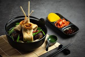 bolo de peixe coreano e sopa de legumes na mesa foto