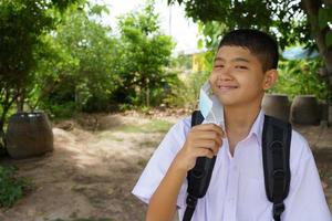 estudante do sexo masculino abre uma máscara mostrando um sorriso feliz. foto