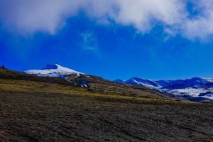 bela paisagem, montanhas cobertas de neve e céu azul foto