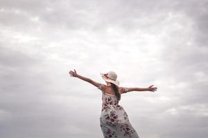 turista feliz mulher solo desfruta de braço aberto sob o céu. foto