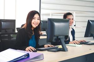 mulher asiática de equipe de negócios jovem trabalhando com fone de ouvido e computador para suporte. foto