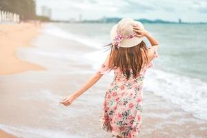 jovem asiática caminhar e relaxar na praia foto