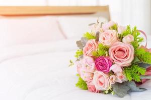 muito lindo buquê de flores colocado em uma cama branca limpa.