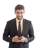 um homem de negócios em um terno que está bem vestido em um telefone celular com um sorriso brilhante isolado em um fundo branco foto