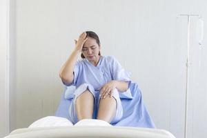 pacientes do sexo feminino asiáticos sentados em leitos hospitalares mostrando desconforto foto