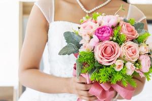 um lindo buquê de flores na mão da noiva que está prestes a entrar na cerimônia de casamento foto