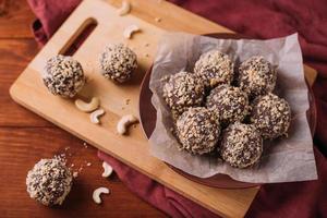 bolas de cacau, bolos de trufas de chocolate a bordo em fundo de madeira foto