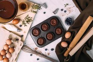 cupcakes com creme e mirtilos na mesa da cozinha foto