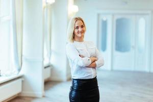 mulher de negócios feliz parecendo confiante com o edifício moderno como b foto