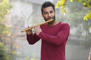 homem tocando flauta - instrumento musical indiano foto