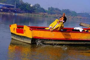 homem desfrutar com água sentado no barco foto