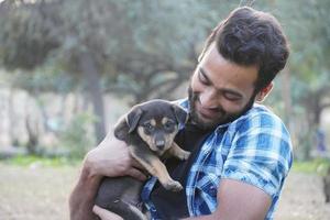 menino com um cachorrinho fofo no parque foto