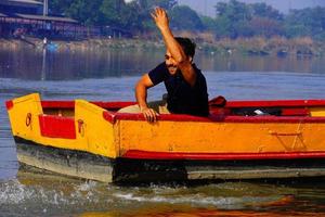 homem desfrutar com água sentado no barco foto